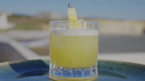 A glass of yellow liquid with a slice of pineapple on top Video stock 306576772