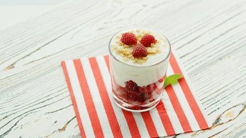 Glass with yogurt and raspberry Stock Footage 111207861
