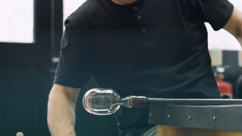 Glassblower blowing pipe while shaping glass Stock Footage 107891028