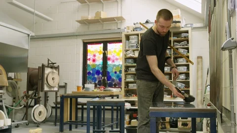 Glassblower cleaning remains from table Stock Footage 107893606