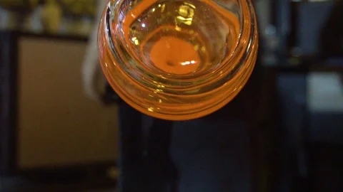 Glassblower in his workshop taking out rod with liquid glass and turning it Stock Footage 108991517