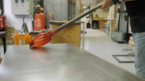 Glassblower shaping molded glass on table in workshop Video stock 107901002