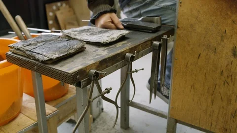 Glassblower using his tools while at work in workshop Stock Footage 107894188