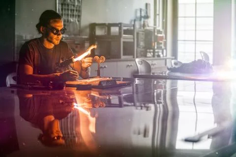 Glassblowing Young Man Working on a Torch Flame with Glass Tubes 스톡 사진