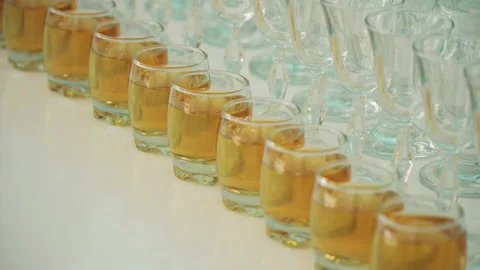 Glasses with alcohol in a row on a white table Stock Footage 154658266