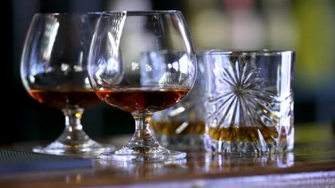 Glasses with alcoholic drinks. Fine spirits at a cozy bar. Stock Footage 311874563