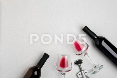 Glasses and bottles of red and white wine on white background from top view Stock Photos