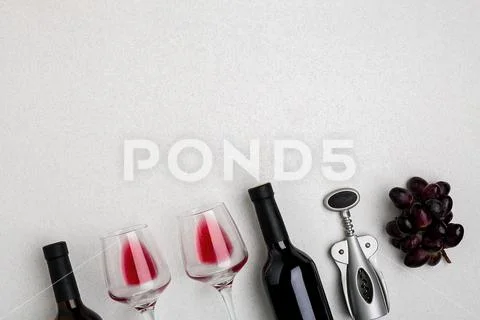Glasses and bottles of red and white wine on white background from top view Stock Photos