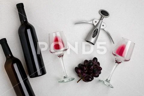 Glasses and bottles of red and white wine on white background from top view Stock Photos
