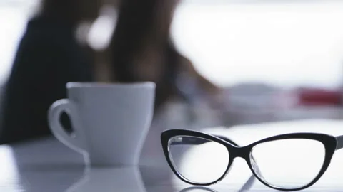 Glasses and a cup of coffee on a table in a cafe. Stock Footage 86165266
