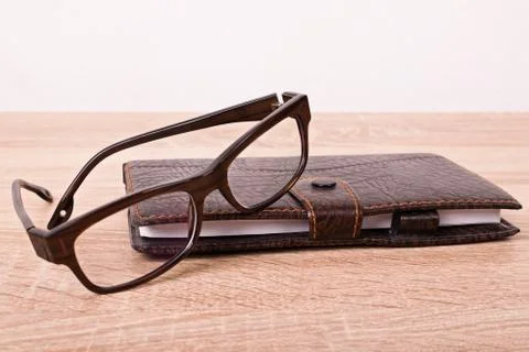 Glasses and a notebook on a table Stock Photos