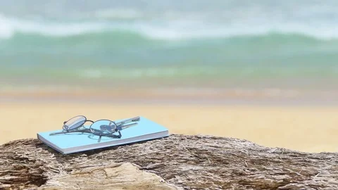 Glasses and notebooks are placed on notebooks beach plate. 库存影片 77552807