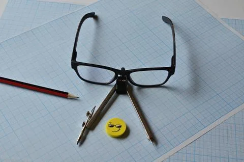 Glasses and objects for drawing on millimeter paper. Fotos de archivo
