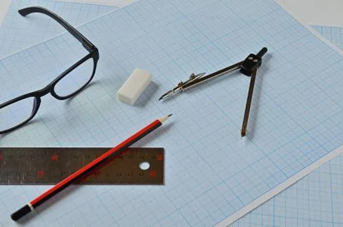 Glasses and objects for drawing on millimeter paper. Fotos de archivo