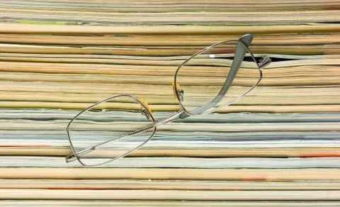 Glasses and stack of magazines 스톡 사진