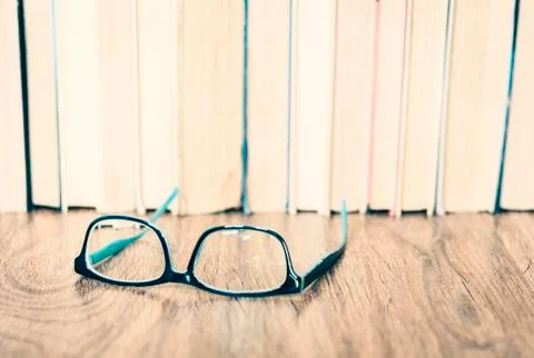 Glasses and stack of old book education concept background, many books piles  Stock Photos