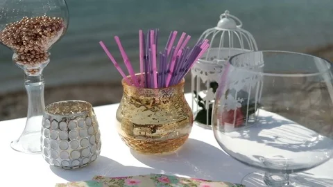 Glasses and vases on table by sand seashore Stock Footage 74823921