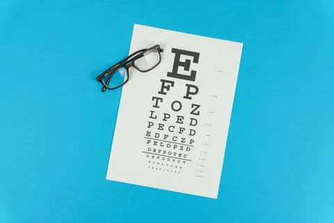 Glasses and a vision test table on a blue background Stock Photos
