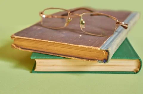The glasses are on top of a stack of old books. Close-up Stock Photos