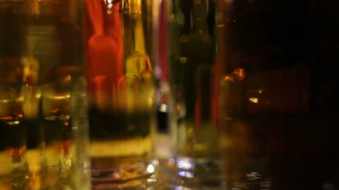 Glasses of beer rotate and switch places. Close-up, real time, indoors, evening Stock Footage 87477617