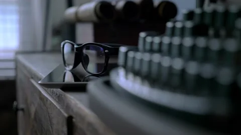 Glasses in black rim lying on a tablet on a wooden dresser in the room, close up Stock Footage 147937301