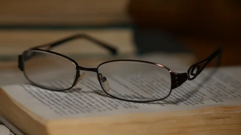 Glasses on the book highlighting with light Stock Footage 92961410
