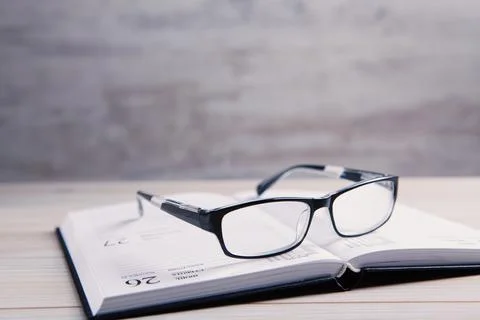 Glasses with a book on the table Stock Photos