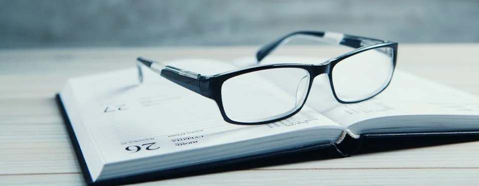 Glasses with a book on the table Stock Photos