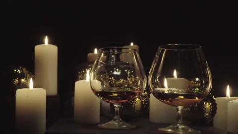Glasses with  brandy on the background of burning candles and Christmas and n Stock Footage 155588349