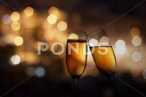 Glasses with champagne against holiday lights Stock Photos