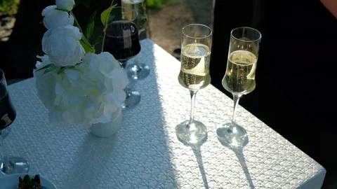 Glasses with champagne stand on a white table Stock Footage 129085086