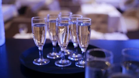 Glasses of champagne on a table in blue light. Champagne bubbles Stock Footage 125756969