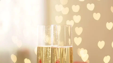 Glasses with champagne, wedding rings and hearted bokeh on wedding day Stock Footage 71982926