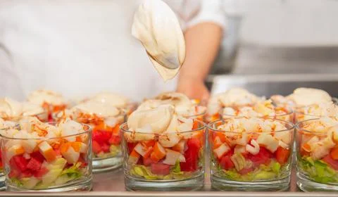 Glasses with chopped prawns with watermelon, crab sticks, lettuce, pink sauce Stock Photos