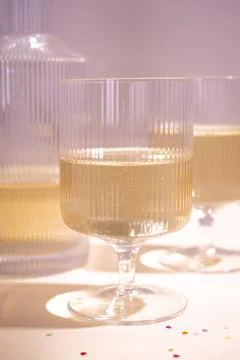 Glasses with cold champagne placed on table on a pink background, closeup. Stock Photos