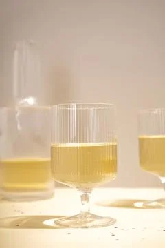 Glasses with cold champagne placed on table in evening lighting. Stock Photos