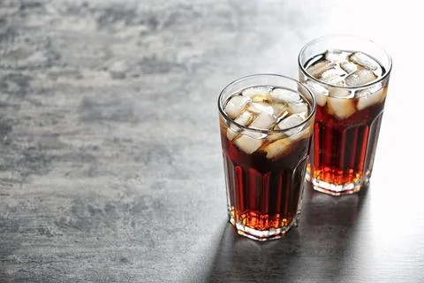 Glasses of cold cola on grey table. Space for text Fotos Stock