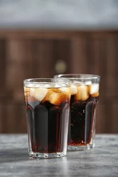 Glasses of cold cola on table against blurred background. Space for text Fotos Stock