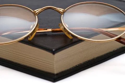 Glasses on the corner of the book. Stock Photos