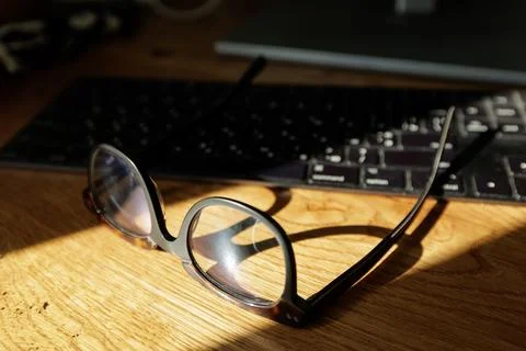 Glasses On Desk In Front Of Computer Keyboard After Screen Work 스톡 사진