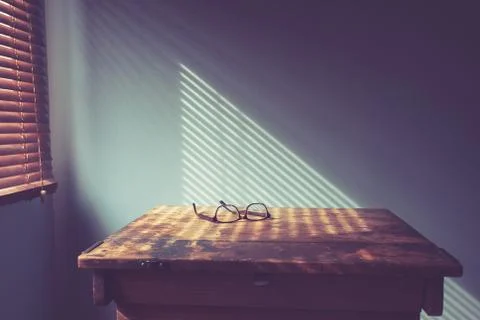 Glasses on desk by window Stock-Fotos