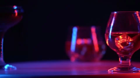 Glasses with different alcoholic drinks stand on a rotating round table. Stock Footage 318387549