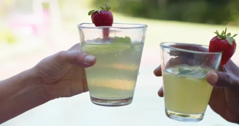 Glasses entering from sides and hands bringing drinks together, creating toast Stock Footage 344385029