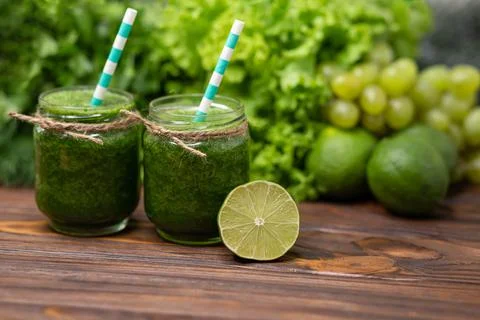 Glasses with green organic smoothie and straw. Green vegetable juice Stock Photos