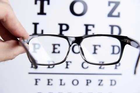 Glasses in the hands on the background of the table for vision Stock Photos