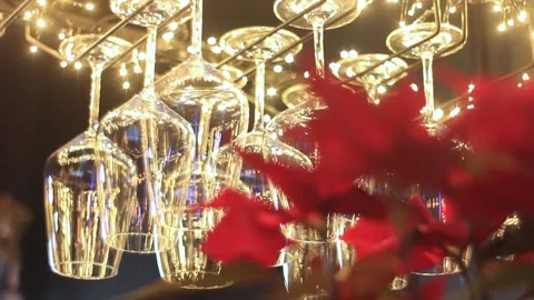Glasses hang on stand with upper illumination in restaurant Stock Footage 192970389