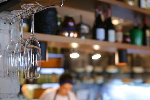 Glasses hanging upside down in cafe restaurant wine Stock Photos