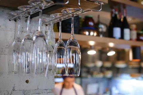 Glasses hanging upside down in cafe restaurant wine Stock Photos