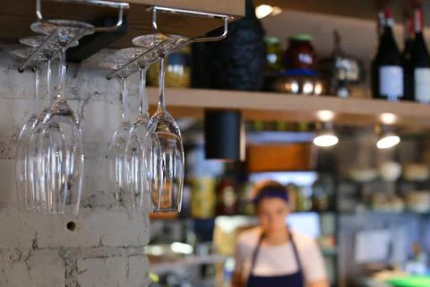 Glasses hanging upside down in cafe restaurant wine Stock Photos