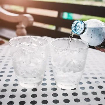 Glasses with ice cubes on black dot background table Stock Photos